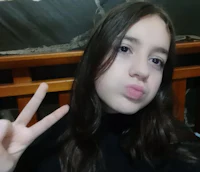 a girl with long hair making a peace sign